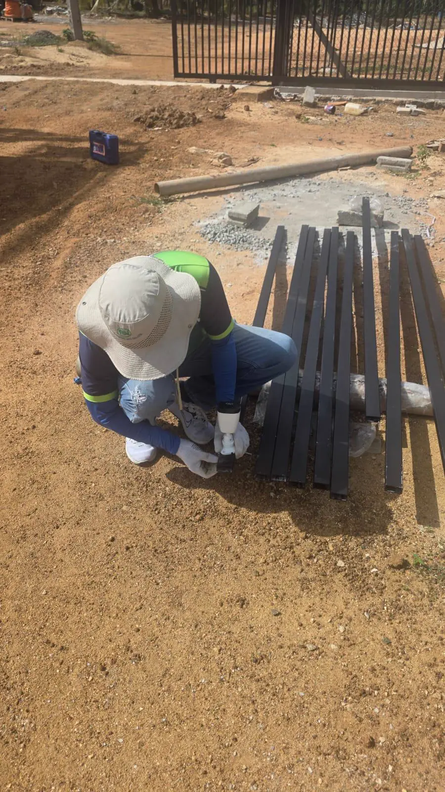 TKWIT technician preparing metal infrastructure components at an outdoor project site in Sri Lanka